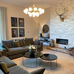 a living room filled with furniture and a fire place in front of a stone wall