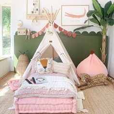 a child's bedroom with a teepee tent and stuffed animals on the floor