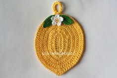 a crocheted lemon ornament with a flower on it's side