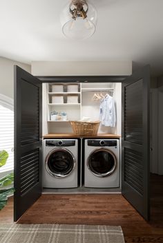 a washer and dryer in a small room with open doors to the closet