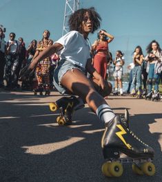 a woman riding a skateboard down a street while people watch from the sidelines