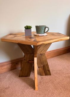 a wooden table with a plant on it and a cup sitting on top of it