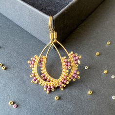 a pair of gold and pink beaded earrings