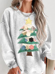 a woman wearing a white christmas tree sweater