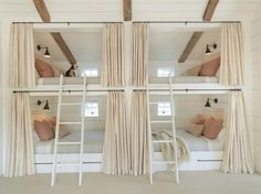 bunk beds with curtains and pillows are in the room that looks like it is made out of wood