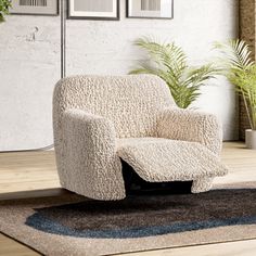 a white chair sitting on top of a wooden floor next to a potted plant