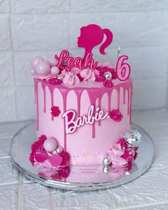 a birthday cake with pink icing and decorations