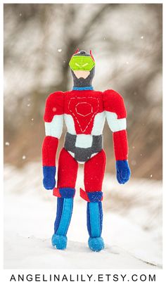 an ornament made to look like a man standing in the snow wearing a red, white and blue suit