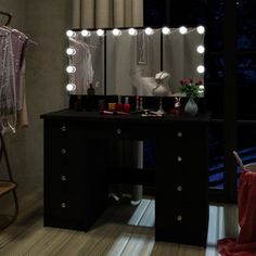 a dressing table with lights on it in front of a window