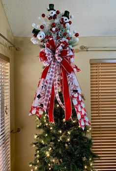 a decorated christmas tree with red and white bows