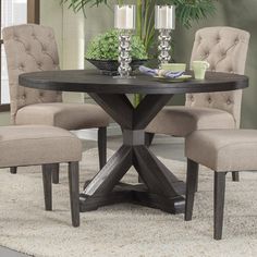 a round table with chairs around it and a potted plant in the corner on top