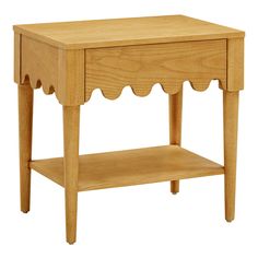 a small wooden table with scalloped legs and a shelf on one side that has a drawer underneath it