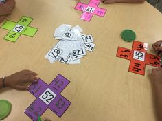 several children are sitting at a table playing with numbers