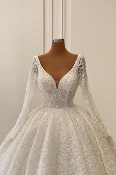 a white wedding dress with long sleeves on a mannequin