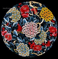 a plate with flowers and leaves painted on the side in blue, red, yellow and white colors