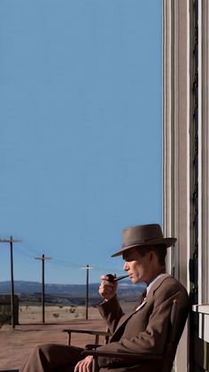 a man in a suit and hat sitting on a bench