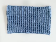 a blue knitted dishcloth on a white surface