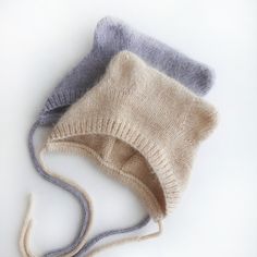 three knitted hats sitting next to each other on top of a white countertop