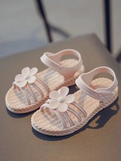 Perfect for sunny days and playful adventures, these sandals combine style and comfort to make every step delightful. These sandals feature a lovely flower design that adds a whimsical touch to any outfit, making them perfect for your little princess. Available in sweet shades of pink, classic tan, and vibrant green, these sandals can match any outfit and occasion. These charming flower embellished woven sandals are a must-have for your little girl's summer wardrobe. Perfect for playdates, picnics, or just a fun day out, these sandals will keep her looking stylish and feeling comfortable all day long. Non-slip Jelly Sandals For Spring, Spring Pink Eva Sandals, Pink Eva Sandals For Spring, Cute Open Toe Jelly Sandals, Cute Open Toe Plastic Sandals, Cute Eva Open Toe Sandals, Cute Plastic Sandals For The Beach, Cute Beach Sandals With Round Toe, Cute Adjustable Jelly Sandals For Spring