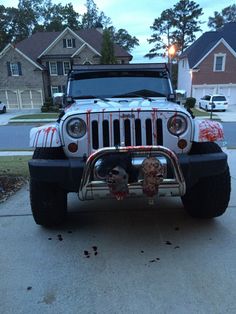 a white jeep parked in front of a house with blood all over it's hood