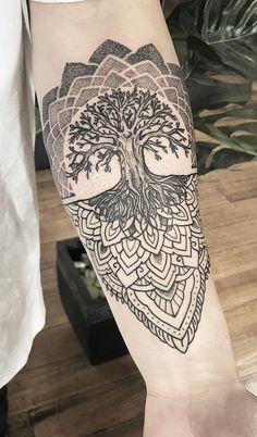 a tree tattoo on the arm with an intricate design