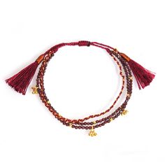 Handmade beaded bracelet Garnet beaded triple strand bracelet with gold ball dangles and tassel closure Smokey quartz beaded triple strand bracelet with gold ball dangle accents Available in Smokey Quartz and Garnet Adjustable Braided Bracelet With Round Beads, Adjustable Woven Braided Bracelet With Round Beads, Adjustable Tassel Jewelry For Festive Occasions, Braided Beaded Bracelets For Festivals, Bohemian Woven Braided Bracelets, Festive Adjustable Beaded Bracelets Hand-strung, Adjustable Beaded Bracelet With Dangling Beads For Gifts, Traditional Adjustable Multi-strand Beaded Bracelet, Festive Adjustable Hand-strung Beaded Bracelets