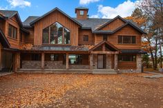 a large wooden house with lots of windows and wood sidings on the front of it