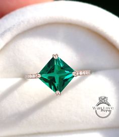 a close up view of a ring with an emerald colored stone in it's center