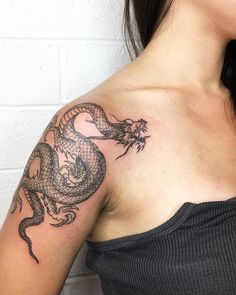 a woman with a dragon tattoo on her shoulder