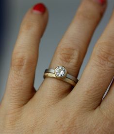 a woman's hand with a ring on it and a diamond in the middle