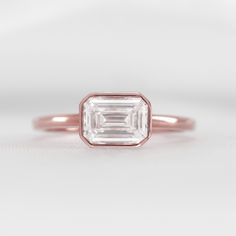 an emerald cut diamond in a rose gold band