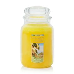 a jar filled with yellow liquid sitting on top of a white table