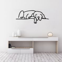 a white wall with a black line drawing of two dogs on it's side