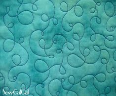 the back side of a quilted material with blue swirls and hearts on it