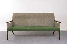 a green couch sitting on top of a gray floor