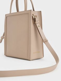 This product is made with at least 20% sustainable materials by weight. CHARLES & KEITH uses recycled, degradable, organic, and water-based materials in our eco-conscious collection. If you prefer a lighter and softer alternative to black, this neutral-toned tote bag in taupe is just as versatile. It features a structured and angular silhouette that is a perfect blend of form and function. Opening up to a spacious interior, it will be able to hold everything you need in a day with ease. Carry yours by the double top handles or attach the adjustable strap to turn it into a shoulder bag. Taupe Colour, Size Chart For Kids, Charts For Kids, Charles Keith, Printables Kids, Neutral Tones, Belt Size, Comfortable Shoes, Latest Fashion