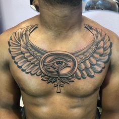 a man's chest with an eye and wings tattoo on the upper half of his body