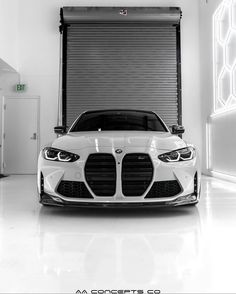 a white car parked in front of a garage door