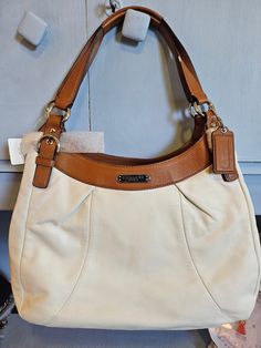 Beautiful vintage Coach with cream leather and saddle leather finishes. Pink Satin inside with large openings! Classic Cream Bags With Leather Lining, Classic Shoulder Bag With Lined Interior, Cream Shoulder Bag With Leather Trim, Classic Shoulder Bag With Lined Interior For Shopping, Beige Shoulder Bag For Travel With Lined Interior, Beige Leather-backed Tote Satchel, Cream Leather Shoulder Bag With Leather Trim, White Leather Bag With Leather Trim, White Leather Bags With Leather Trim