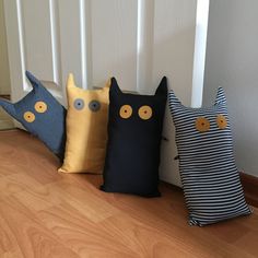 four decorative pillows are lined up on the floor