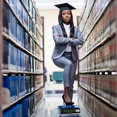 a woman in a suit and hat standing on books