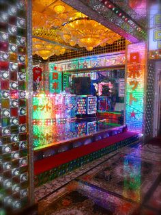 a brightly lit room filled with lots of colorful lights and mirrors on the wall above it