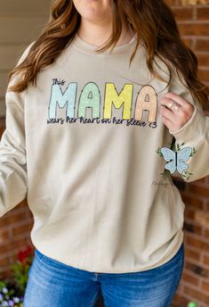 Show off your love and style with our This Mama Wears Her Heart On Her Sleeve personalized crewneck sweatshirt! Made with high-quality fabric for all-day comfort, this sweatshirt is the perfect way to express your love for your little ones. Get ready to turn heads and melt hearts with this unique and meaningful piece. Long Sleeve Cotton Sweatshirt With Heart Graphic, Cotton Sweatshirt With Heart Graphic And Long Sleeves, Cotton Sweatshirt With Heart Graphic, Long Sleeve, Casual Oversized Sweatshirt With Heart Graphic, Casual Long Sleeve Sweatshirt With Heart Graphic, Casual Spring Sweater With Heart Graphic, Trendy Long Sleeve Sweatshirt With Heart Graphic, Spring Long Sleeve Sweatshirt With Heart Graphic, Long Sleeve T-shirt With Heart Graphic For Fall