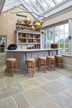 an image of a kitchen setting with barstools and stools in the center