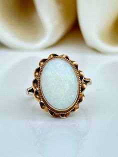 Vintage 9ct Yellow Gold Large Cabochon Opal Ring  Truly beautiful fiery opal with spilt shoulders  The item comes without the box in the photo but will be presented in a Gembank1973 gift box Measurements: weight 3.72g, size UK M US 61/2, head of ring 17mm x 14mm, height off finger 7mm Materials: 9ct yellow gold and Opal   Hallmarks: stamped 9.375 Condition: The overall condition is very good Office use: USZ Luxury Heirloom Cabochon Opal Ring, Antique Oval Opal Ring As Gift, Vintage Oval Cabochon Opal Ring Gift, Classic Cabochon Opal Ring Gift, Classic Cabochon Opal Ring As Gift, Antique Style Opal Ring For Formal Occasions, Classic Cabochon Opal Ring For Anniversary, Victorian Cabochon Opal Ring For Gift, Victorian Opal Cabochon Ring As Gift