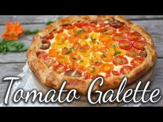 a pizza sitting on top of a wooden table next to an orange and green flower