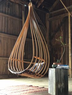 a wooden hanging chair in an old barn