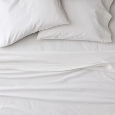 white sheets and pillows are on top of each other in this bedding set that is made up