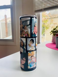 a can with pictures of people on it sitting on a table in front of a window