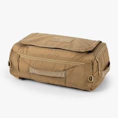 a tan duffel bag sitting on top of a white floor